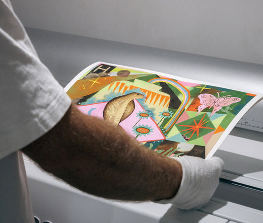 A person holding and looking at coloured print for detail